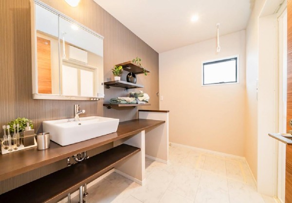 ゆとりの洗面スペースで朝の身支度も快適スムーズに。三面鏡で髪のセットやお化粧もストレスなくこなせ、朝から気分良く通勤通学に向かえそうですね！鏡の裏にはたっぷりと収納スペースを標準装備！