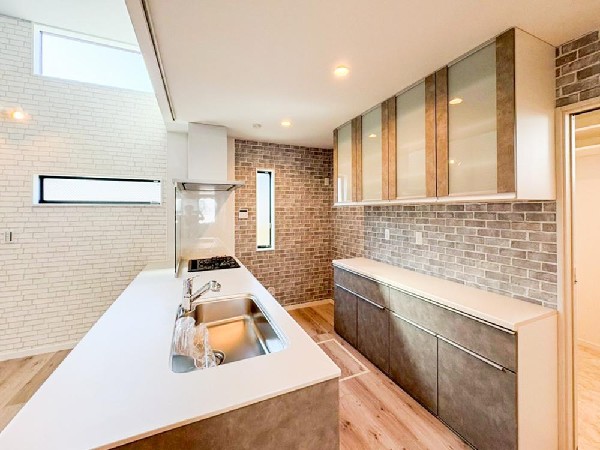 リビングに降り注ぐ明るい陽射しがそのままキッチンにも柔らかく降り注ぐ明るい印象のキッチン廻り。リビングとキッチンの間に壁を設けてないフルオープンタイプですので、空間に一体感を感じられます。