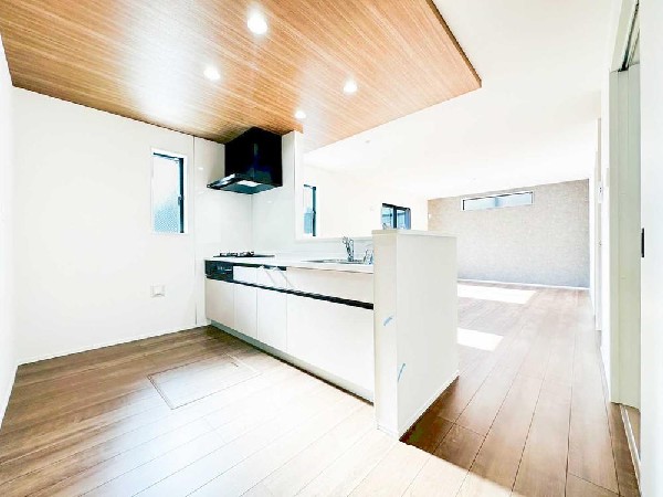 木目天井が映える開放的なLDK。対面キッチンから室内全体を見渡せ、家族との会話を楽しみながら家事ができる心地よい空間です。