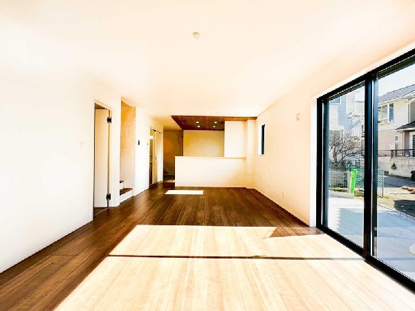 大きな窓から陽光が差し込む明るいLDK。キッチンとの一体感があり、家族が自然と集まる開放的な空間です。