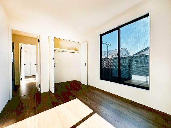 シンプルで整った内装の洋室。大きな窓による明るさと収納付き設計で、家具配置もしやすい快適なプライベート空間です。