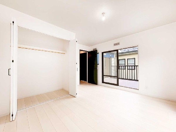 白い床と大きな窓が明るさを引き立てる洋室。バルコニーにつながる開放感と、ワイドクローゼットの収納力が魅力の上質な空間です。