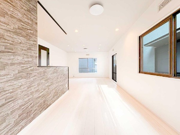 白基調の明るいLDKは、ワイドな開放感が魅力。石目調のアクセントが空間に上質さを添え、2面採光で一日中心地よく過ごせる住まいです。