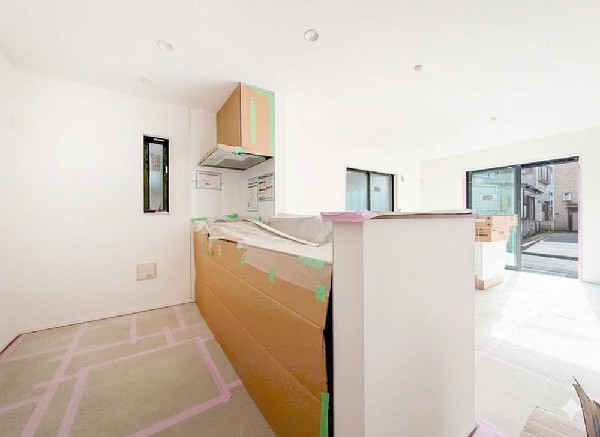 家族の様子を見守りながら調理できる対面キッチン。完成前につき養生中ですが、LDKの広がりを感じられます。※建物完成前につき、養生中の状態です。実際の仕上がりとは異なります。