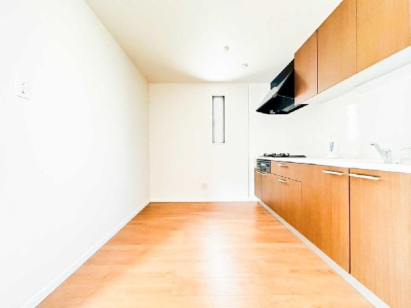 奥までしっかり広がるキッチンスペースで、ゆとりある動線を実現。木目キャビネットが映えるスッキリとした壁付けキッチンは、収納も作業もしやすい快適仕様です。