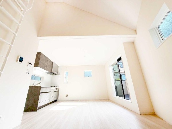 勾配天井が生み出す開放感あふれるLDK。3方向から柔らかな光が届き、どの時間帯も明るく快適に。省スペース設計ながら、空間の広がりをしっかり感じられる住まいです。