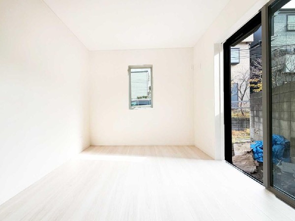 大きな掃き出し窓から柔らかな光が入る明るい洋室。家具が配置しやすいシンプルな形で、主寝室としてもゆったり使える落ち着いた空間です。