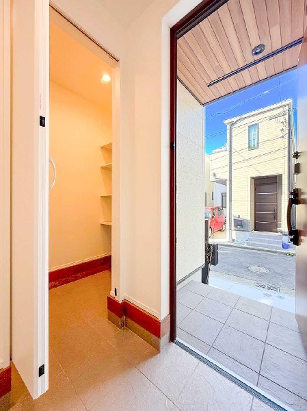 外観:木目天井とタイル仕上げが迎える、上質なエントランス。SICと一体で使いやすく、住まいの第一印象を高めます。