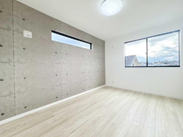 無機質な質感が映えるアクセントウォールが印象的な洋室。家具を選ばず、インテリア次第で表情を変えられる洗練空間です。