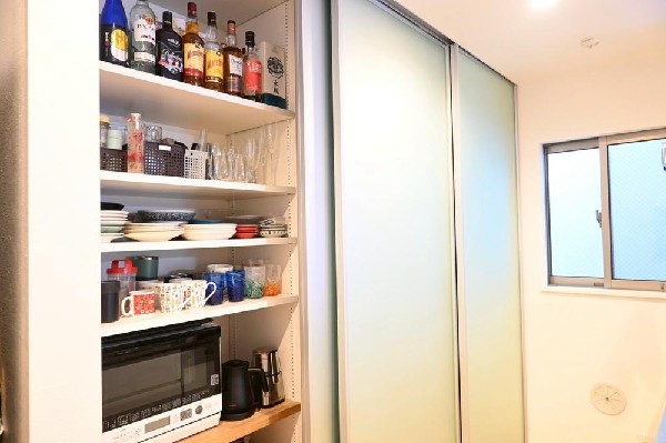 背面にカップボードが備え付けされています。システムキッチンと一体感あるカラーで見た目もgood。たまにしか使わない調理家電の収納に重宝します。