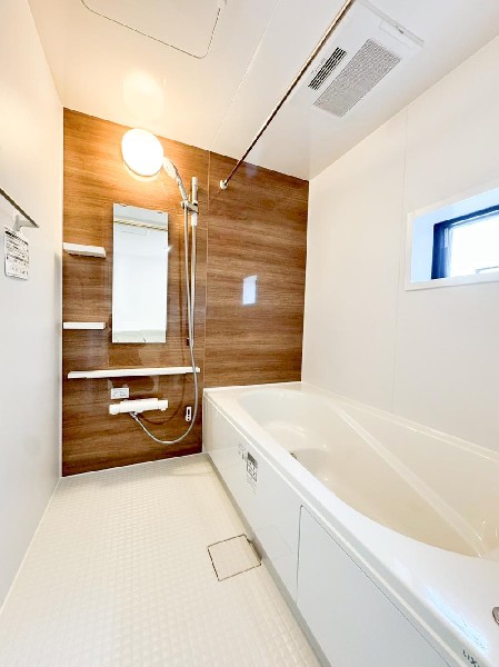 木目調アクセントパネルが落ち着きを演出するバスルーム。浴室暖房乾燥機付きで快適性にも配慮。ゆったりとした浴槽で一日の疲れを癒せます。