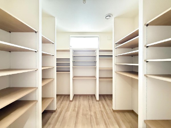 廊下に大容量収納を設置。倉庫スペースは商品保管やコレクション用途に活用可能で、棚壁は撤去すれば居室としても利用できます。