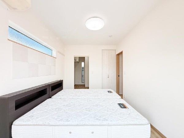 窓から陽光が差し込む明るい居室。日中は自然光で心地よく過ごせ、開放感のある快適な住空間を演出します。