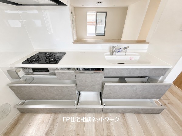 スライド収納付きのシステムキッチン。料理器具なども収納できて出し入れもスムーズ。収納量もたっぷりなので料理器具やストック調味料なども入れられる。
