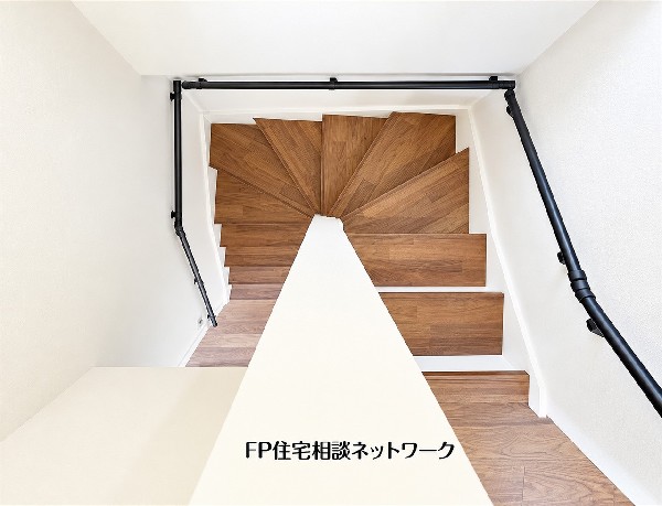 木目調の踏み板と黒い手すりが映える階段。白い壁とのコントラストが美しく、毎日の上り下りにも住まいのデザインを感じられます。