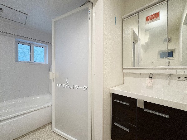 清潔感あふれる洗面室とバスルーム。明るく広々とした空間に、機能的な収納と大きな鏡が備わり、毎日の支度も快適に。