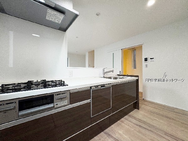 光沢のあるキッチンが高級感を演出。広々としたカウンターで家族と会話を楽しみながら料理ができる、快適で機能的な空間です。 