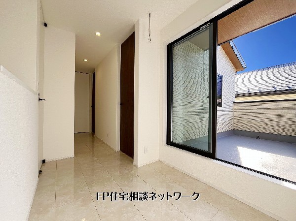 大きな窓からバルコニーとつながる明るい2階ホール。タイル床が上質感を演出し、光と風を感じながら家族が行き交う心地よい共用空間です。