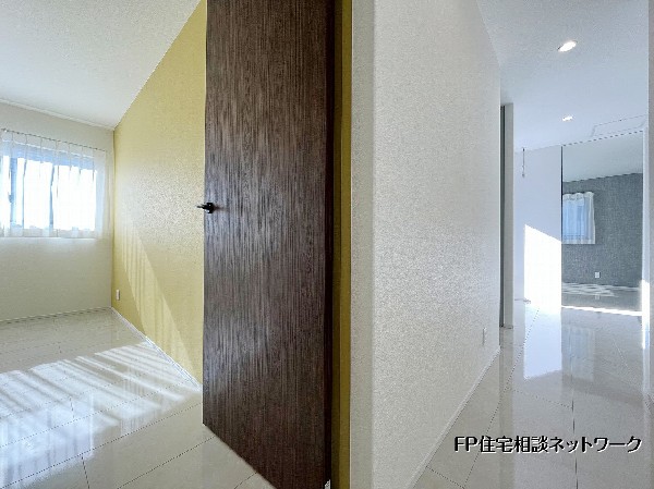 明るい光が差し込むタイル張りの廊下。アクセントクロスが空間に彩りを添え、各居室へと心地よくつながる洗練された動線が魅力です。 