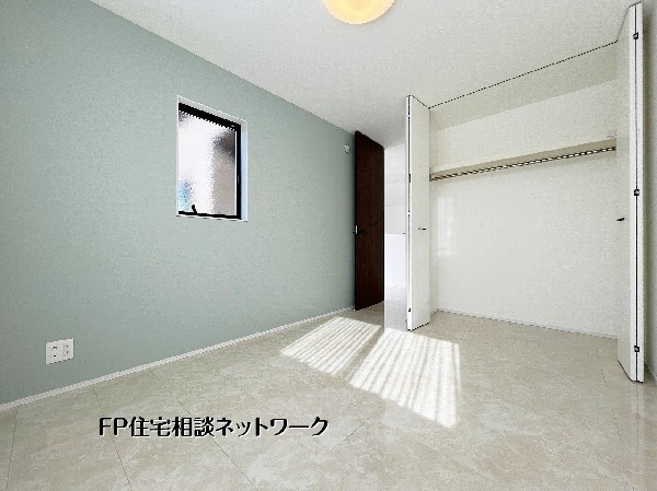 やわらかな採光とアクセントクロスが心地よい居室。クローゼット付きで収納力も確保し、寝室や書斎など多用途に使える落ち着いた空間です。 