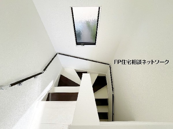 トップライトから自然光が注ぐ明るい階段スペース。白を基調としたデザインに手すりが映え、上下階の移動も心地よく感じられる開放的な空間です。