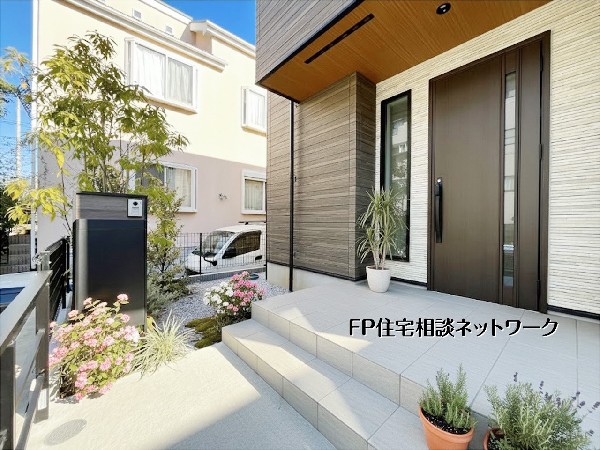 外観:木目天井が映える上質な玄関アプローチ。ゆとりあるタイル階段と植栽が住まう人と来客をやさしく迎え、毎日の帰宅が心地よくなるデザイン性の高い玄関です。