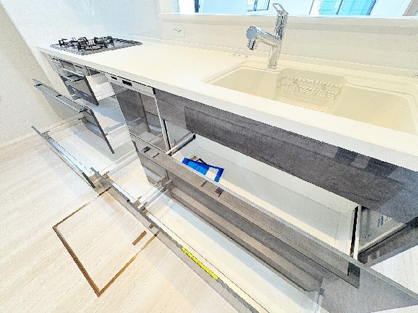 スライド収納付きのシステムキッチン。パスタ鍋や圧力鍋、フライパンなども収納できて出し入れもスムーズ。収納量もたっぷりなので料理器具やストック調味料なども入れられる。