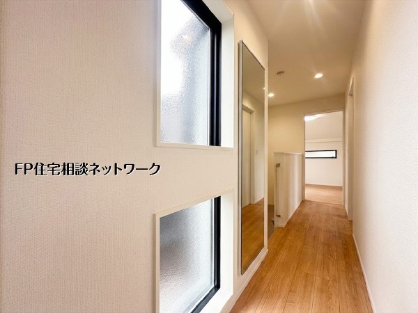 【廊下】白を基調とした清潔感あふれる廊下は、二面配置の窓から優しい光が差し込む明るい設計。身だしなみチェックに便利な大型の姿見が設置されており、お出かけ前もスムーズです。シンプルながらも機能性と美し