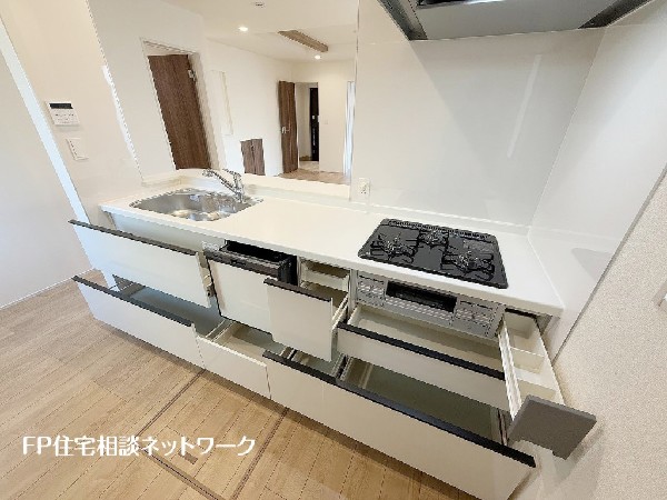 スライド収納付きのシステムキッチン。料理器具なども収納できて出し入れもスムーズ。収納量もたっぷりなので料理器具やストック調味料なども入れられる。