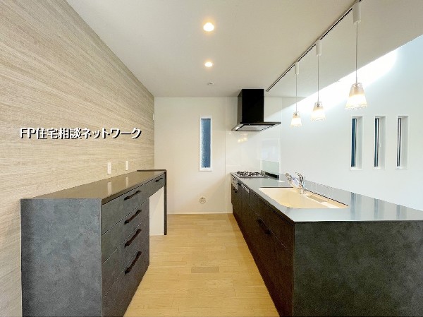 統一感のある落ち着いた色合いが魅力のキッチン。カップボード付きで収納力も豊富です。使い勝手の良い動線とデザイン性を兼ね備えた上質な空間です。