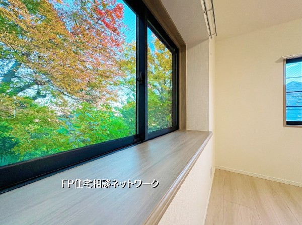 外観:窓枠がまるで額縁のように、外に広がる鮮やかな緑を切り取ります。四季折々の美しい風景が室内に彩りを添え、家にいながら自然の息吹を感じられる贅沢な「借景」のある暮らし。