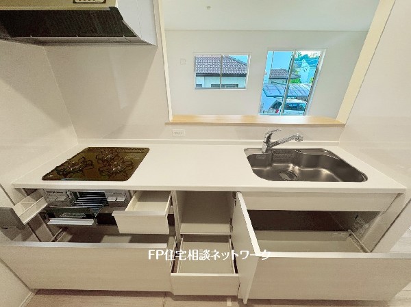 スライド収納付きのシステムキッチン。料理器具なども収納できて出し入れもスムーズ。収納量もたっぷりなので料理器具やストック調味料なども入れられる。