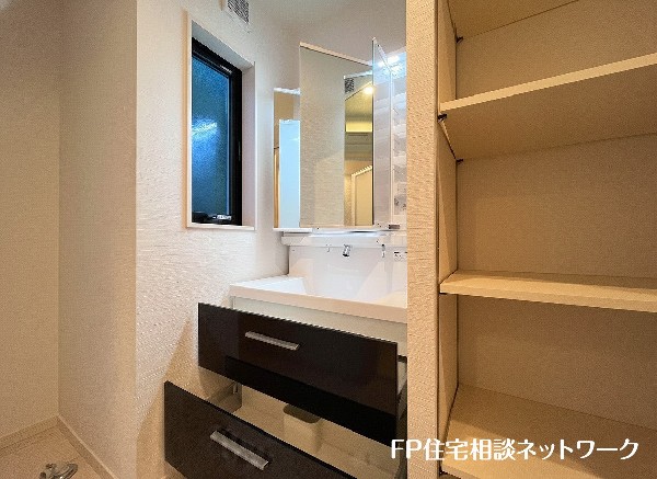 鏡の裏に豊富な収納量を確保した、三面鏡タイプの洗面化粧台。化粧品やティッシュボックス、歯ブラシなどを機能的に収納できるスペースを設えました。いつも清潔に保ちたい洗面室の整頓にも役立ちますね。