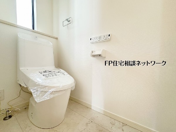 【トイレ】  白を基調とした清潔感のあるトイレです。温水洗浄便座や壁掛けリモコンを完備し、快適な使い心地を実現しました。小窓から自然光が差し込む明るい空間で、心地よさをプラスしてくれます。