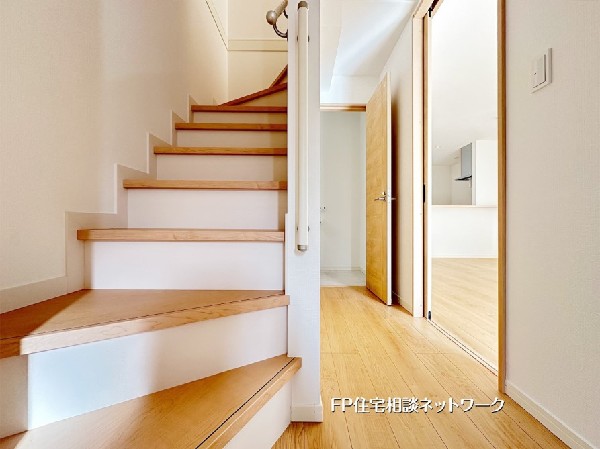 玄関から続く階段がLDKへと自然につながる、開放感のある住空間。明るい木目の床と白基調の内装が調和し、家族の動線もスムーズです。