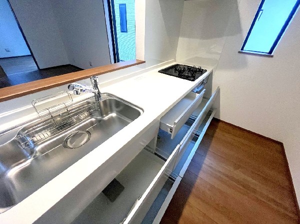 スライド収納付きのシステムキッチン。パスタ鍋や圧力鍋、フライパンなどもおしまい頂け、出し入れもスムーズ。