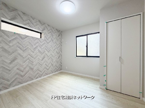 【洋室│4.8帖】  ヘリンボーン柄のアクセントクロスが目を引く、お洒落な洋室です。二面採光で明るく、収納も完備。ナチュラルな色合いの床が温かみを演出し、自分好みのインテリアを楽しめる空間に。