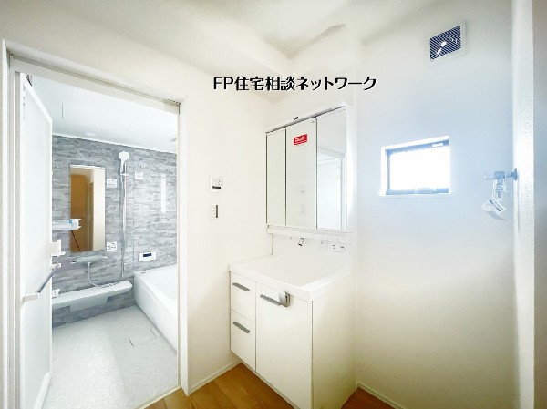 三面鏡の洗面化粧台と小窓で明るく清潔な洗面室。脱衣スペースも広く、朝の支度がスムーズ。浴室との動線が良く、家事効率も高まる便利な空間。