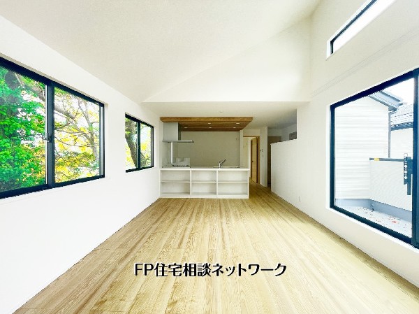 大きな窓から光が降り注ぐ明るいLDK。高い天井が生む圧倒的な開放感と、バルコニーへ続く心地よい動線が魅力です。緑を感じながら過ごせる快適な空間。  