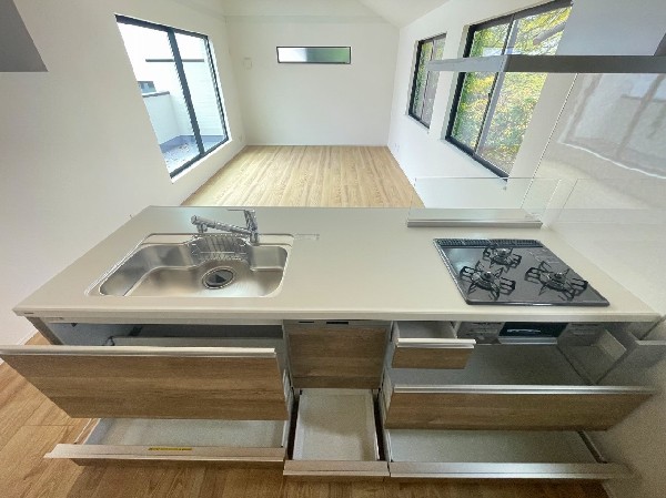 大容量の引き出し収納で使い勝手抜群のシステムキッチン。リビングを見渡せる開放的な配置で、家事をしながら家族との時間も楽しめます。明るく快適な空間。