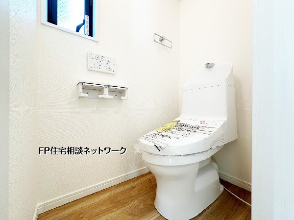 小窓付きで明るく換気もしやすい清潔感あるトイレ空間。節水型タンクレスデザインでお手入れも簡単。落ち着いて使える快適な設備です。