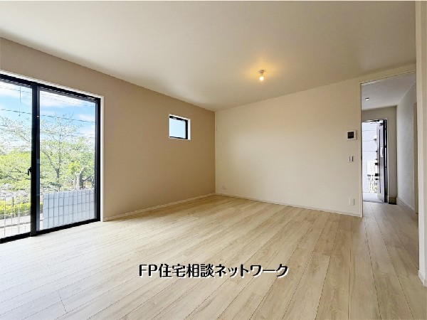 【リビング】  落ち着いたアクセントクロスが洗練された空間を演出するLDK。大きな窓からは豊かな緑と光が入り込み、開放感にあふれています。家族が自然と集まりたくなるような、心地よい住空間です。