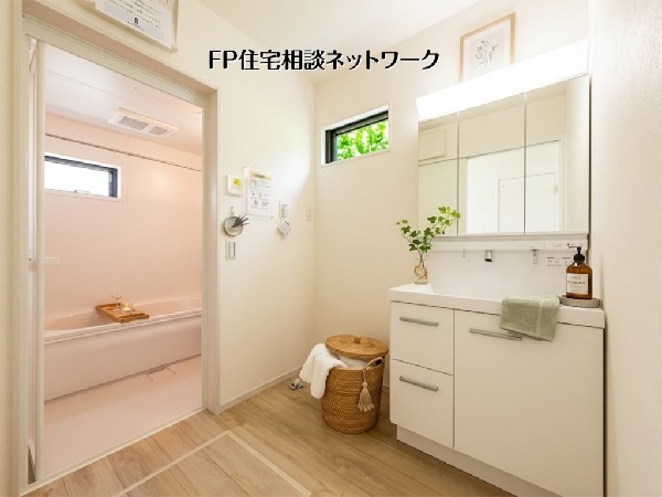 【洗面脱衣室】  白を基調とした清潔感あふれる洗面室。三面鏡付きの洗面台は収納力も高く、朝の身支度を快適にサポートします。優しい印象のバスルームが続き、リラックスタイムを演出します。