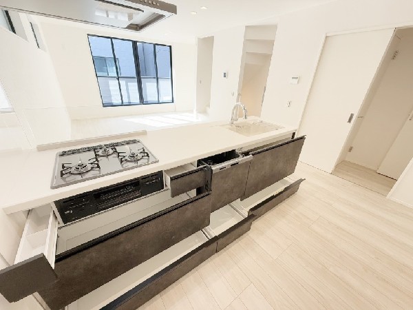 スライド収納付きのシステムキッチン。料理器具なども収納できて出し入れもスムーズ。収納量もたっぷりなので料理器具やストック調味料なども入れられる。