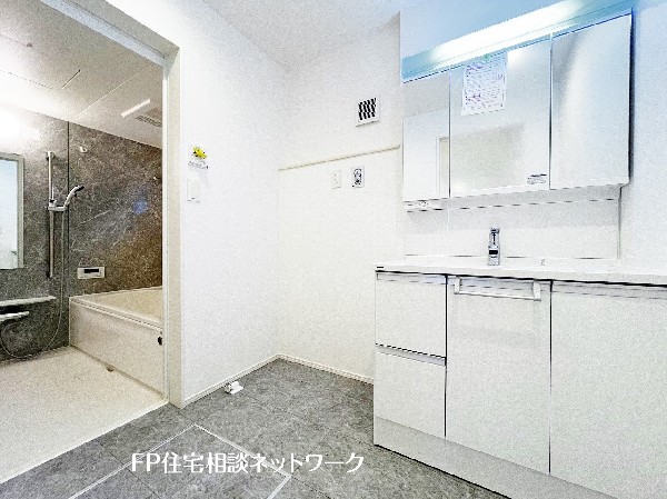 広々とした洗面室は、収納力のある三面鏡キャビネットとワイドな洗面台が魅力。タオルや洗剤もすっきり収まり、家事動線の良いバスルーム直結設計。お子様の身支度も並んでできるゆとりある空間です。 