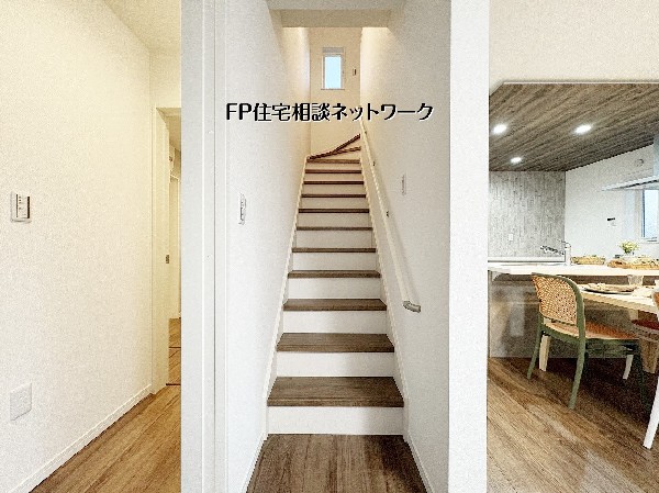 【リビングイン階段】  キッチン横に配置された階段で、上下階の移動もスムーズ。白を基調とした清潔感ある内装に、木目調のアクセントが温かみを添えます。採光窓のある階段は日中も明るく、家族の気配を感じる間取