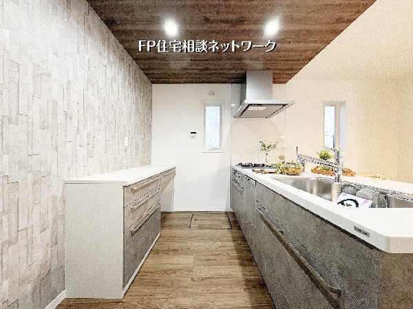 【キッチン】  木目調の天井とグレーの石目調キッチンが織りなす、洗練されたカフェのような空間。充実のカップボードで収納力も抜群です。質感豊かなアクセントクロスが、日々の料理時間を上質なひとときへと変えて