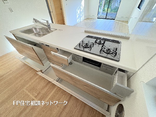 収納力抜群のシステムキッチン。大容量の引き出しで調理器具もスッキリ整理。作業しやすい広い天板と三口コンロで毎日の料理が快適になります。