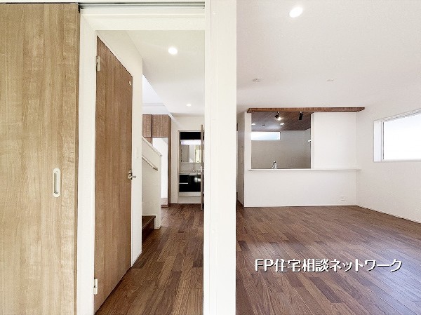 玄関ホールからリビングへの視線の抜けが美しい空間。天井の高低差や建具の配置が、空間にリズムを生み出しています。木の温もりを感じるナチュラルな内装が、住まう人を優しく包み込む安らぎのLDKです。