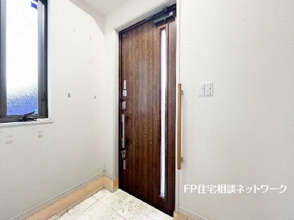 玄関ホールには大きな窓があり、自然光が射し込み、住まう人、訪れる人を心地よく迎え入れてくれる。玄関収納には、ディスプレイスペースがあり、お花、グリーンなどを飾れる。